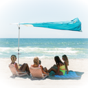 People sitting under a Solbello beach umbrella on a sandy beach with ocean view